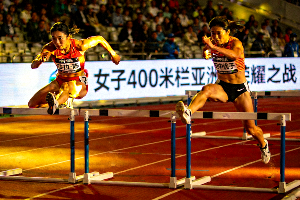 女子400米栏亚洲荣耀之战：中国选手莎拉·陈与日本选手田中优子在跨栏瞬间的竞争画面